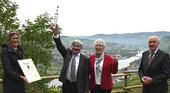 Hans und Maria Wirtz freuen sich über die Auszeichnung. Mosel-Weinprinzessin Julia Gries, und Kammerpräsident, Ökonomierat Norbert Schindler (rechts) übergeben die Siegerbrand-Urkunde.