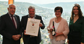 Kammerpräsident, Ökonomierat Norbert Schindler (li.), und Moselweinkönigin, Sarah Röhl, überreichen die Siegerweinurkunde für das Weingut Lönartz-Thielemann, Ernst.