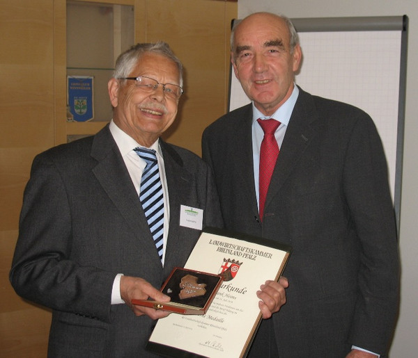 Zwei Herren bei der Übergabe einer Auszeichnung.