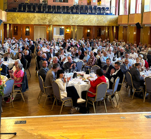 Viele Menschen im Saal an runden Tischen