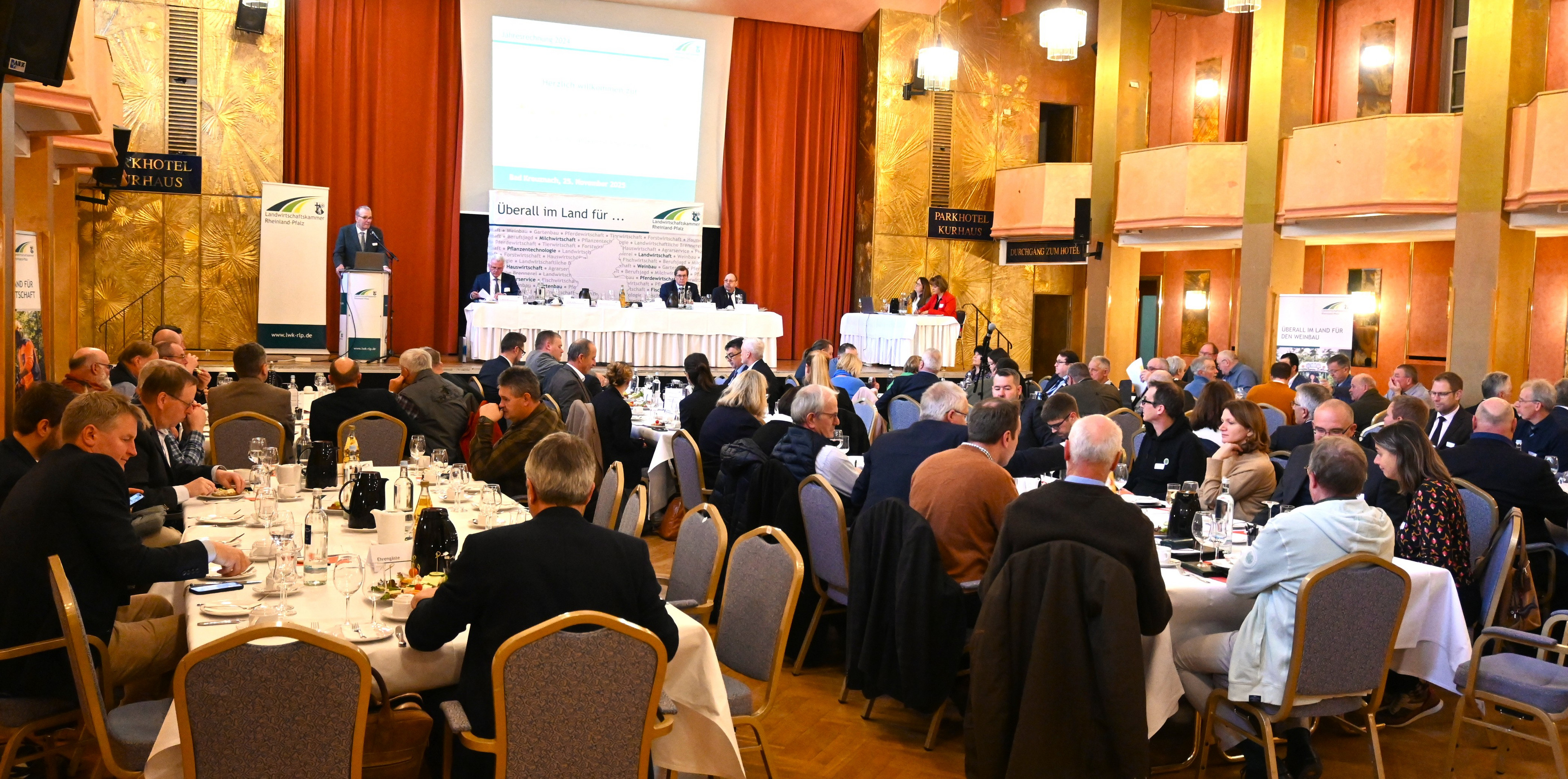 Delegierte an Tischen, vorne ein Podium.